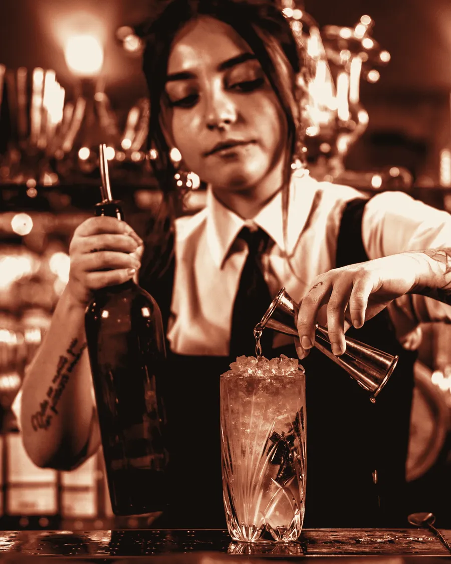 Bartender measuring Estrato from a jigger